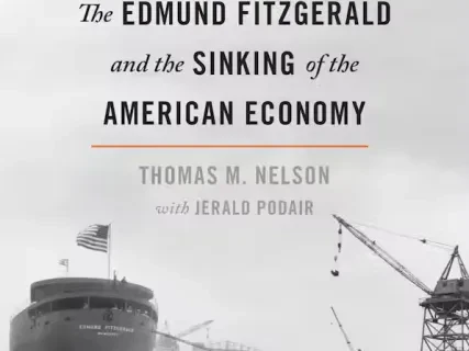 Black and white photograph of a large ship under construction with cranes nearby, titled "Wrecked."