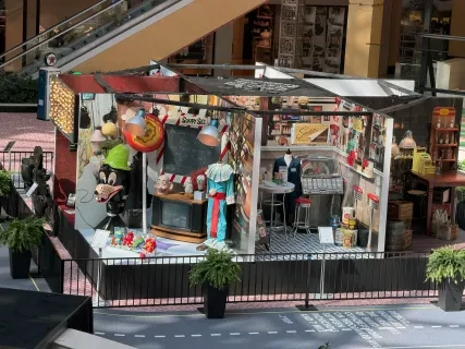 Shopping mall display with carnival games, toys, and colorful decorations.
