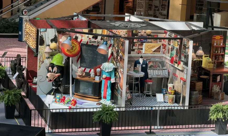 Shopping mall display with carnival games, toys, and colorful decorations.
