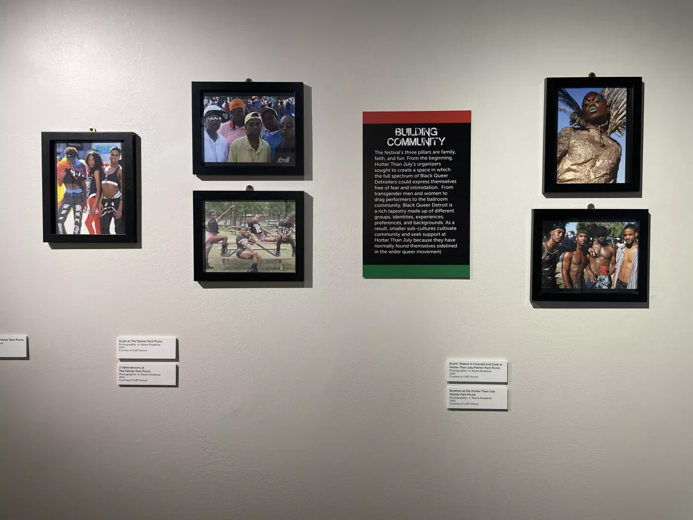 Framed photographs and text displayed on a gallery wall.
