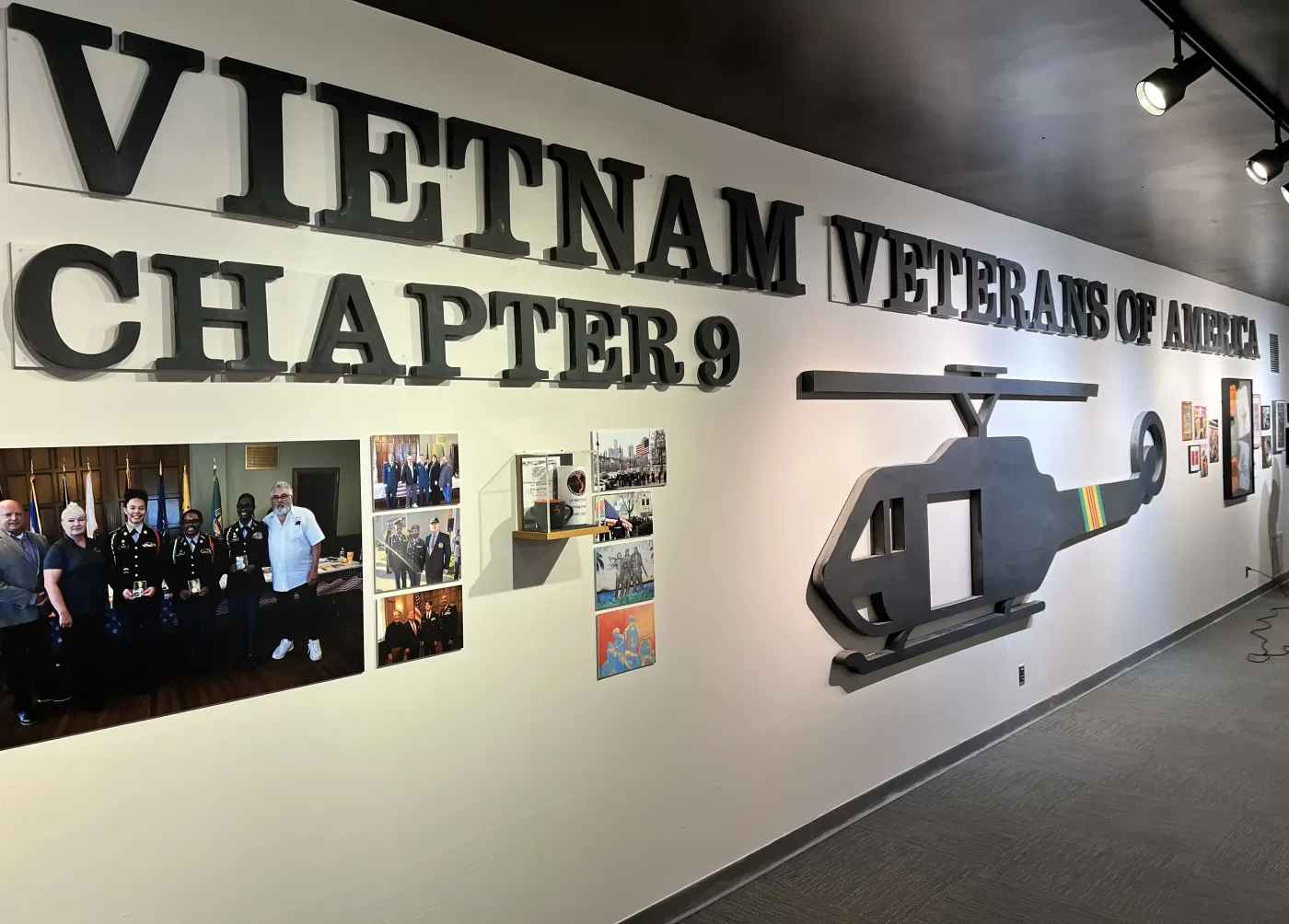 Wall display with "Vietnam Veterans of America Chapter 9" text, helicopter silhouette, and group photos.
