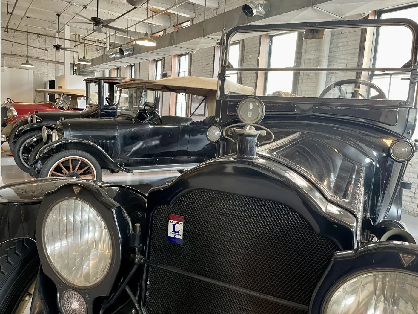 Vintage black cars lined in a well-lit garage.