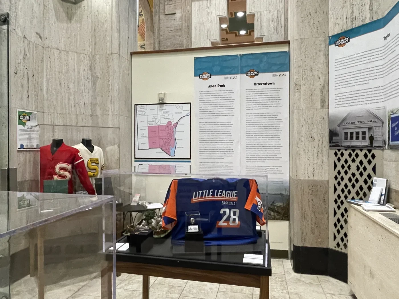 Museum exhibit with sports jerseys, historical plaques, and display cases.