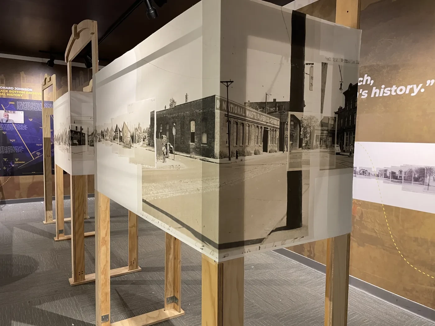 Sepia-toned photographs on display boards in an exhibition setting.