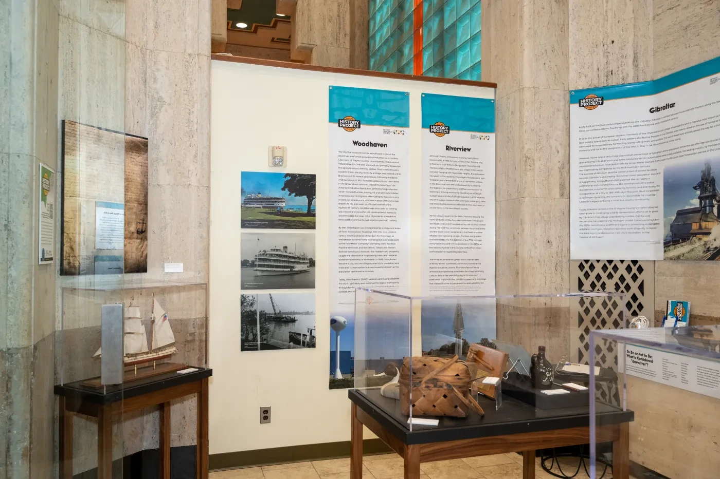 Museum exhibit with model ships, historical photos, and text panels on display.